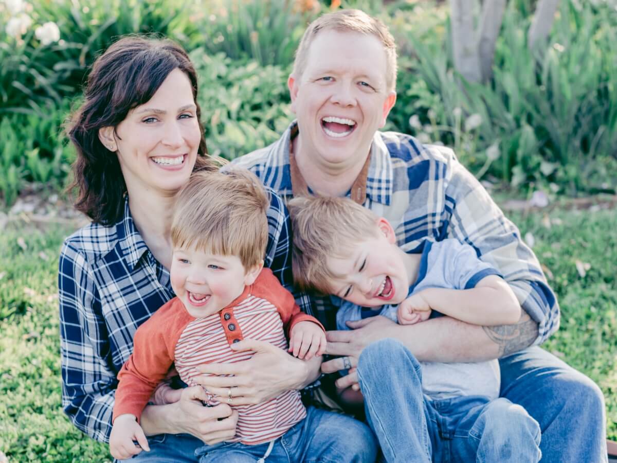 amy and gabe outside in a family photo with their two sons, with everyone laughing