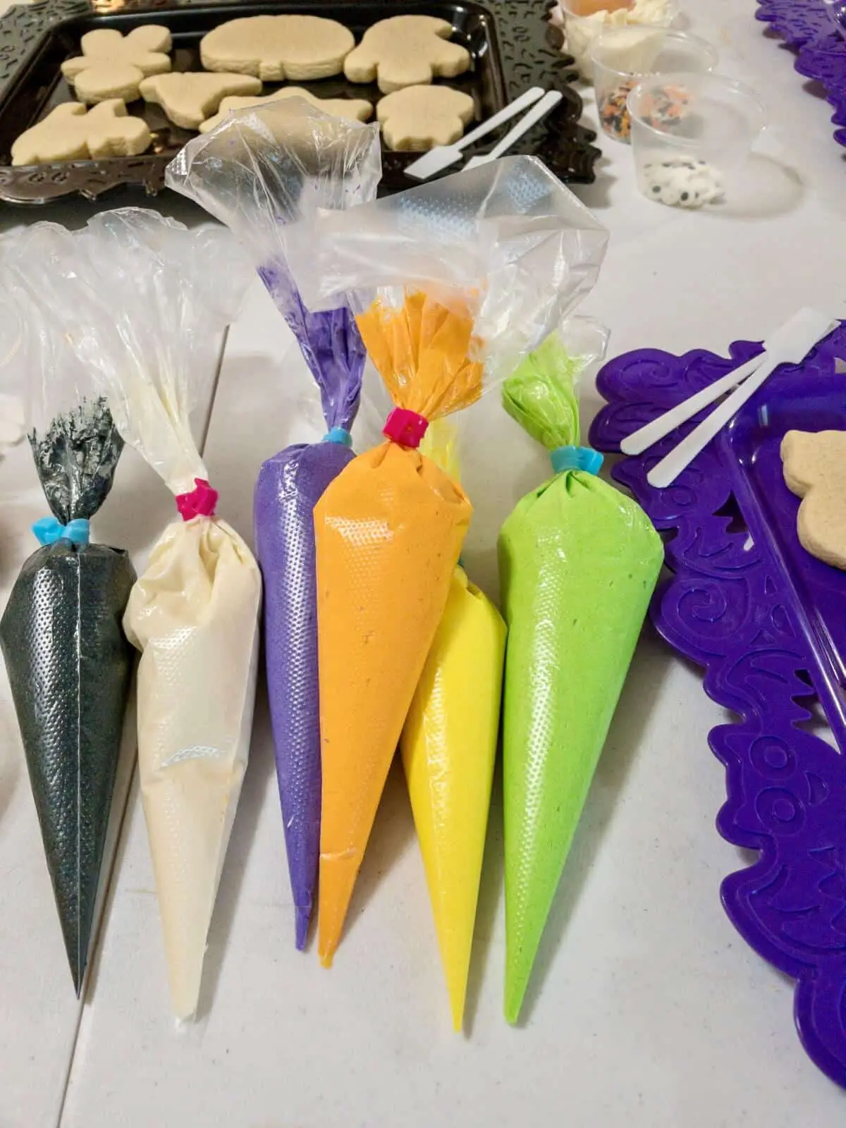 Several disposable piping bags filled with colorful buttercream frosting.