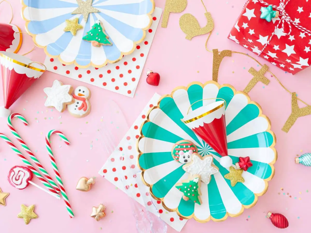 Colorful Plates with a pink tablecloth and Christmas candy decorations.
