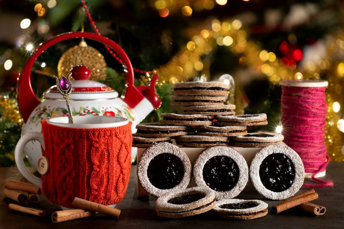 A tea kettle with English biscuits and Christmas decor in the background.