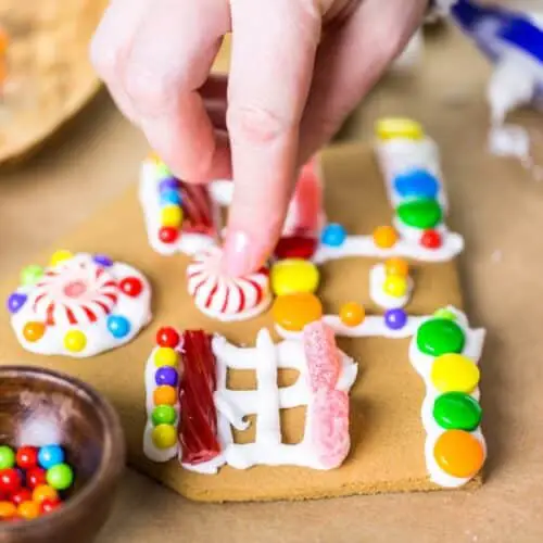 A gingerbread house piece being decorated.