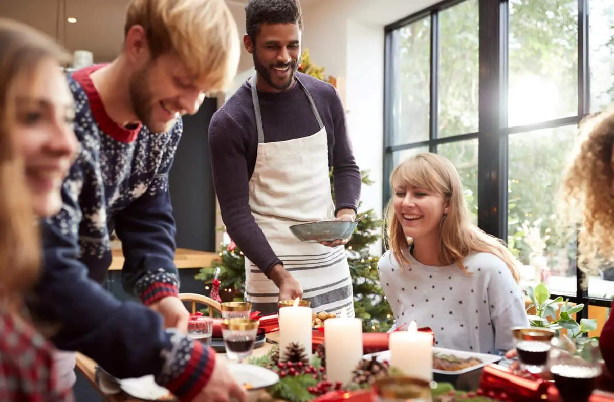 Friends gathering at a Christmas dinner party with food.