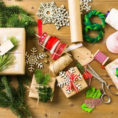 Christmas wrapping paper and wrapping supplies on a table.