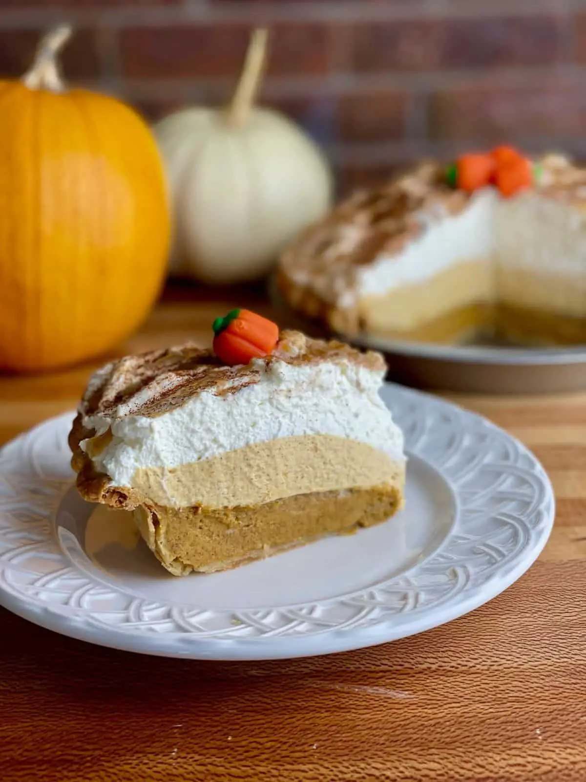 A slice of triple layer pumpkin cream pie with three distinct layers