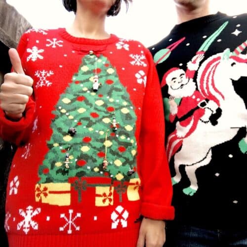 Two people in ugly sweaters at a themed Christmas party.