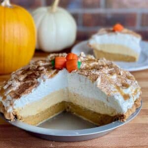 A whole Pumpkin Cream Pie cut open to show layers of pumpkin pie, pumpkin mousse, and whipped cream.