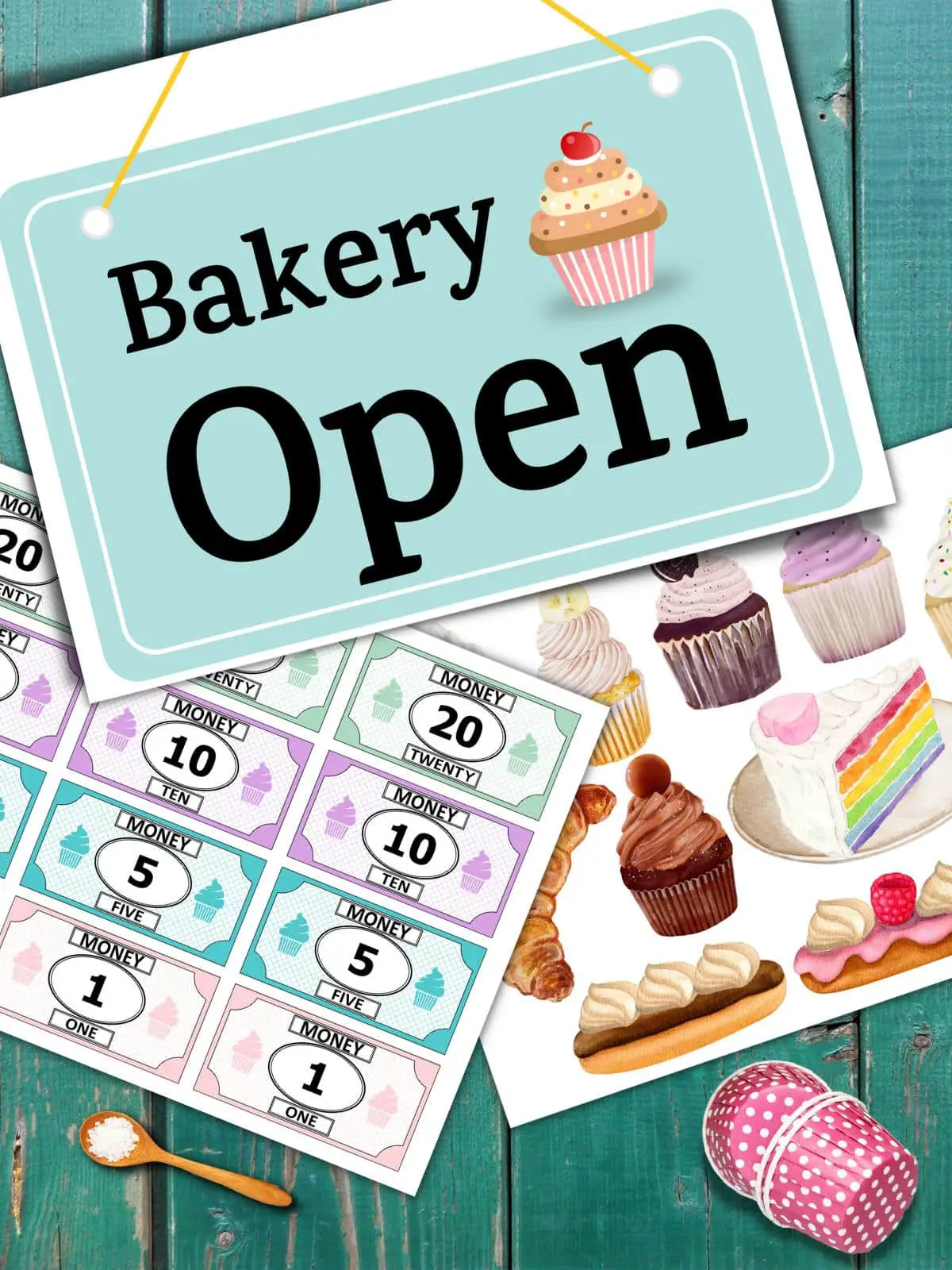 A table with printed bakery dramatic play pages including play money, desserts, and an open sign