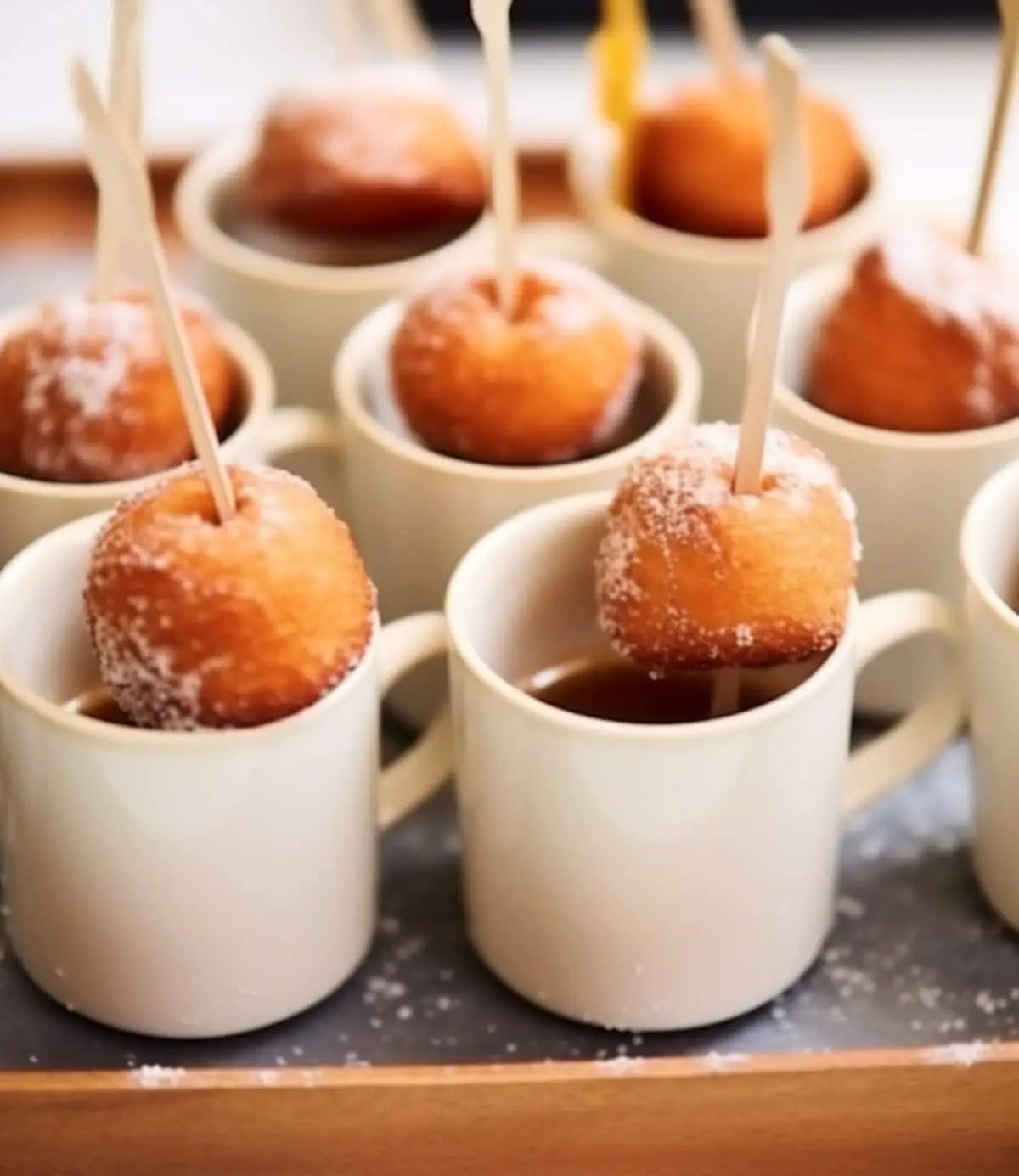Small party coffee cups with a skewer with a donut hole on it.