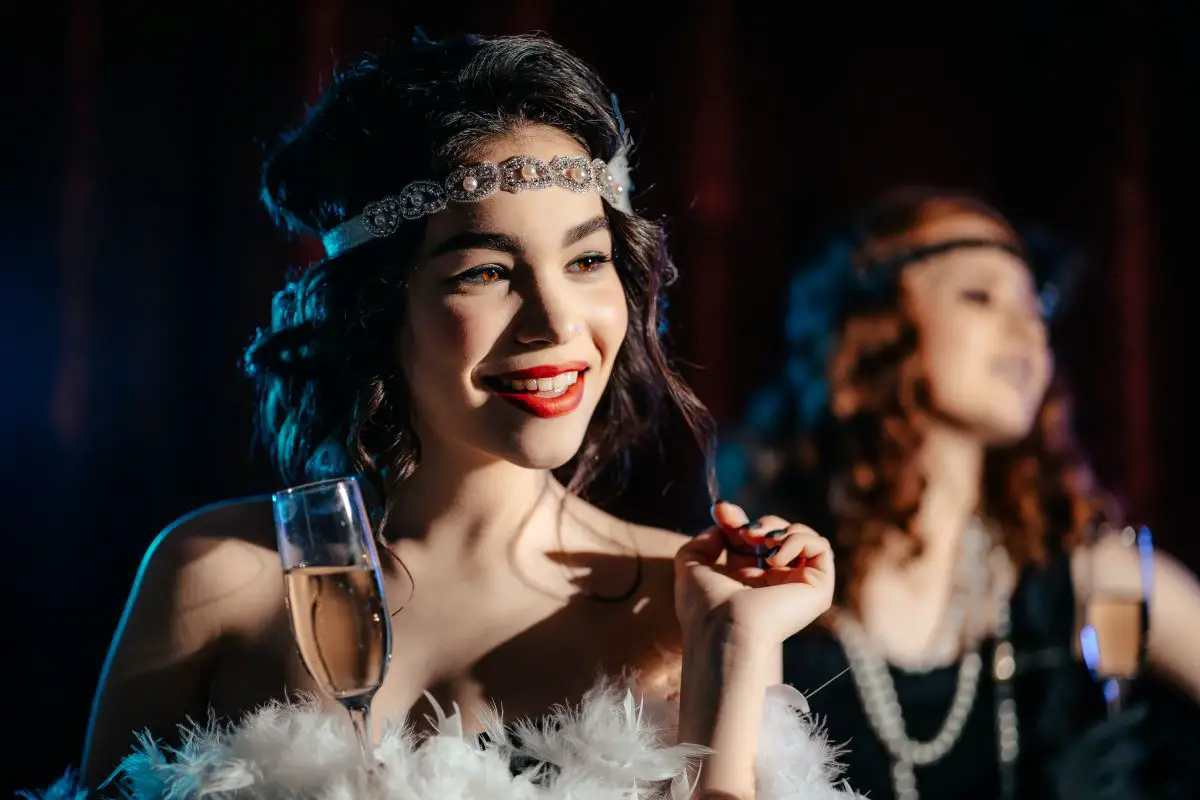 Two women in flapper costumes at a great gatsby party.